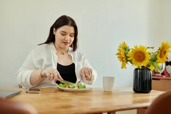 A cheerful woman savors a healthy meal while surrounded by sunflowers. — Stock Photo
