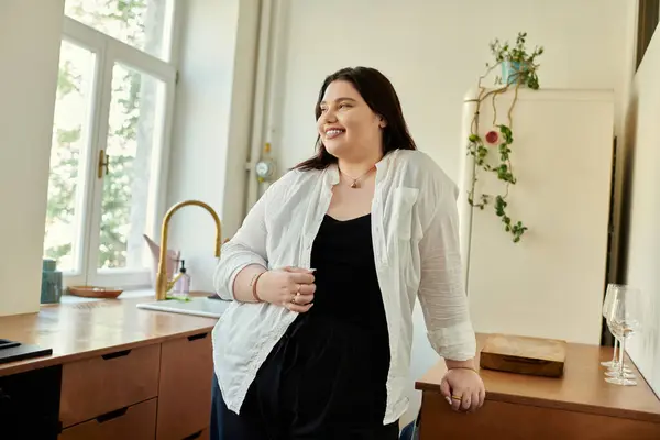 A plus size woman enjoys her time at home in a stylish kitchen. — Stock Photo
