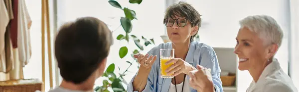 Una amorevole famiglia LGBTQ condivide la colazione, piena di risate e conversazioni significative. — Foto stock