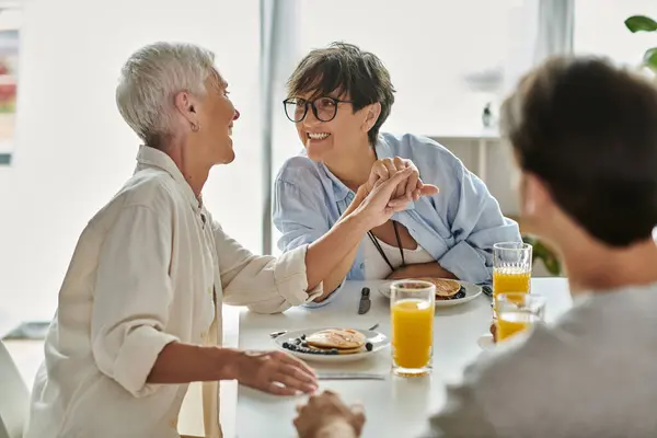 A warm breakfast shared among a loving LGBTQ family enjoying laughter and connection. — Stock Photo