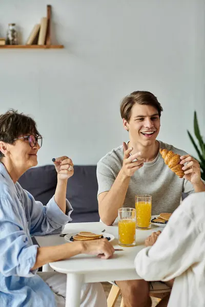 A loving LGBTQ family shares breakfast, enjoying each others company and delicious food together. — Stock Photo