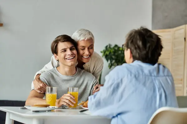 A loving LGBTQ family enjoys breakfast, sharing smiles and laughter at their cozy dining table. — Stock Photo