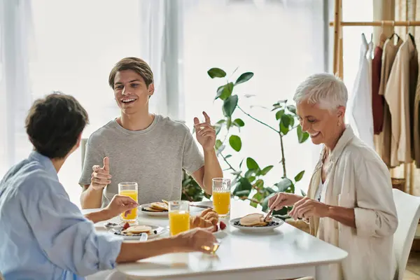 A loving LGBTQ family enjoys breakfast together, filled with laughter and warmth in a cozy space. — Stock Photo