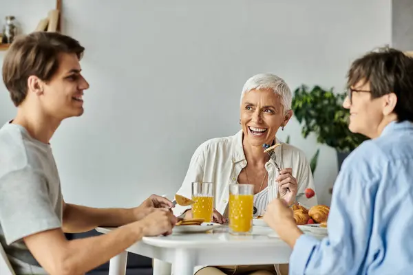 A loving family shares a cheerful breakfast filled with laughter and delicious food in a cozy kitchen. — Stock Photo