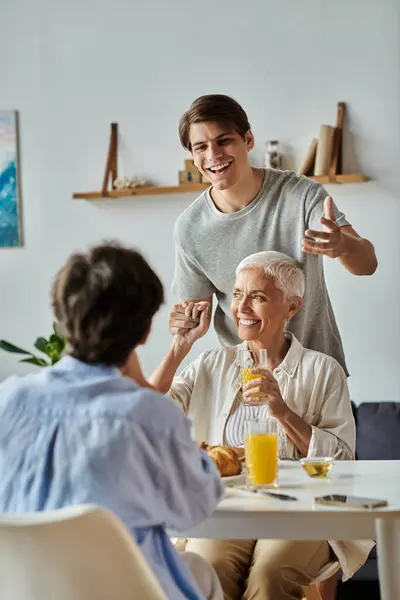 A loving LGBTQ family shares a joyful breakfast, filled with laughter and connections at a sunny table. — Stock Photo