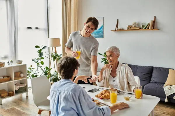 A loving family shares a joyful breakfast, with laughter and conversation filling the bright, cozy space. — Stock Photo