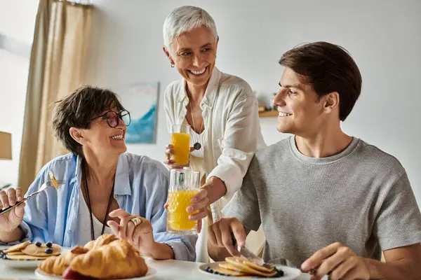 A loving family shares laughter and a delightful breakfast at home, savoring moments and flavors together. — Stock Photo