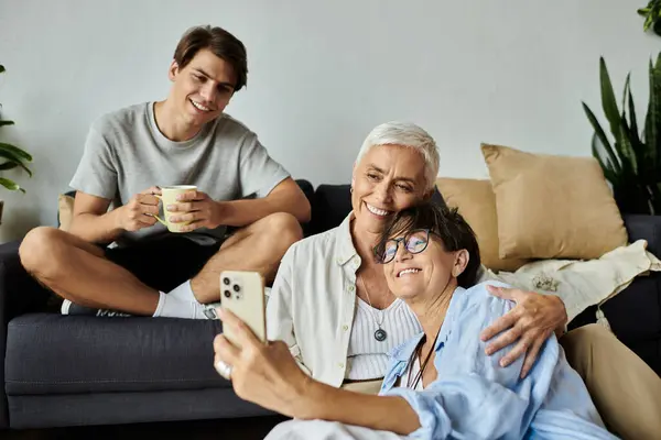 Three family members share laughter and joy while capturing a fun moment together. — Stock Photo