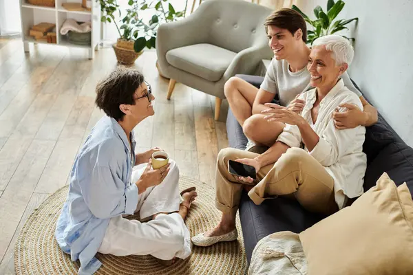 A joyful moment shared by a loving LGBTQ family, exchanging laughter and stories in a warm setting. — Stock Photo