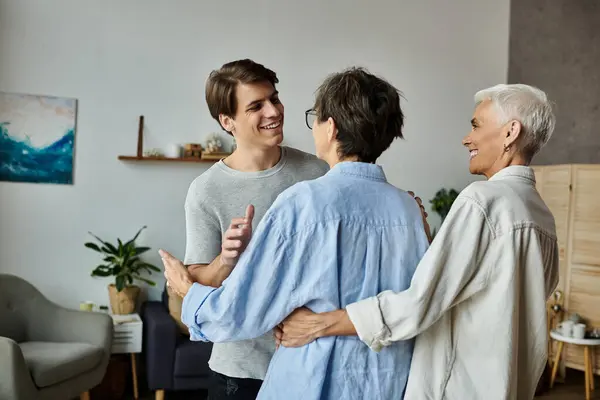 A vibrant family moment unfolds as a son shares laughter and warmth with his lesbian parents. — Stock Photo