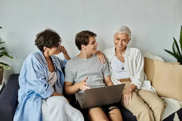 A joyful family of three shares laughter and stories while enjoying time together on the couch. — Stock Photo