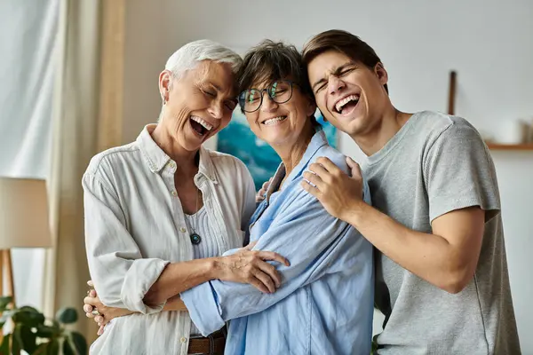 Genitori lesbiche e il loro figlio adulto godono di un momento commovente pieno di risate a casa. — Foto stock