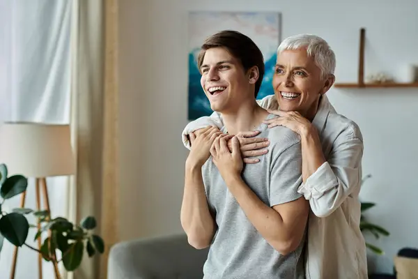 A heartwarming bond is shared as a mother playfully embraces her son in a bright, cozy living room. — Stock Photo