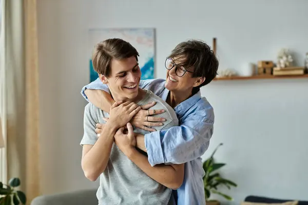 A middle-aged mother shares a warm embrace with her adult son in a bright and inviting living space. — Stock Photo