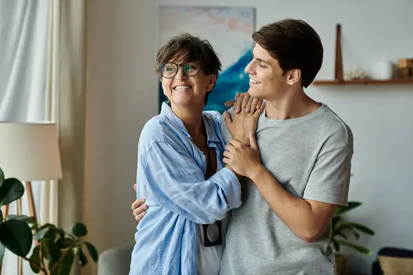 A middle-aged mother joyfully shares a warm embrace with her adult son, cherishing their bond. — Stock Photo