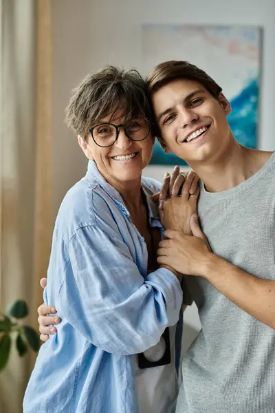 A middle-aged mother and her adult son share laughter and warmth in their cozy living space. — Stock Photo