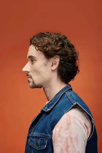 A striking man expresses deep emotion in a colorful studio setting. — Stock Photo
