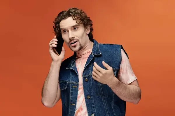 Bonito homem apaixonadamente falando ao telefone em um ambiente colorido. — Fotografia de Stock