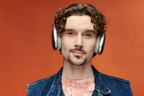 Emotional man enjoys music, expressing joy and creativity in a colorful environment. — Stock Photo