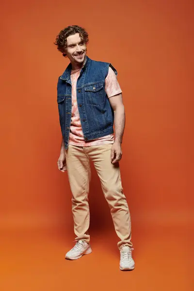 Man showcasing a joyful expression in a striking orange setting. — Stock Photo