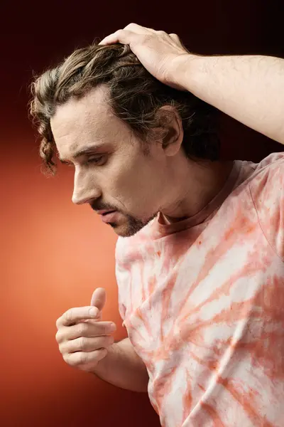 Un homme frappant exprime une émotion profonde sur un fond vif. — Photo de stock