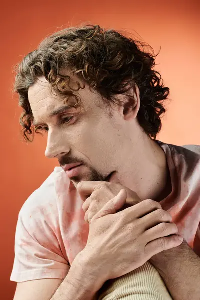 A thoughtful man contemplates while seated against a bright, colorful background. — Stock Photo