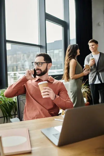 Colleagues discuss plans while one makes a call in a stylish office environment. — Stock Photo