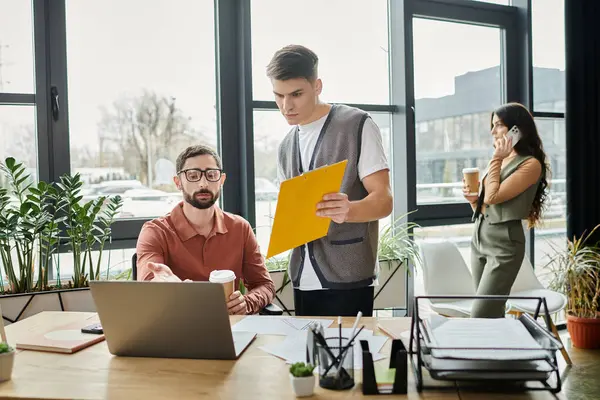 Two colleagues engage in a serious conversation while a third talking by phone. — Stock Photo
