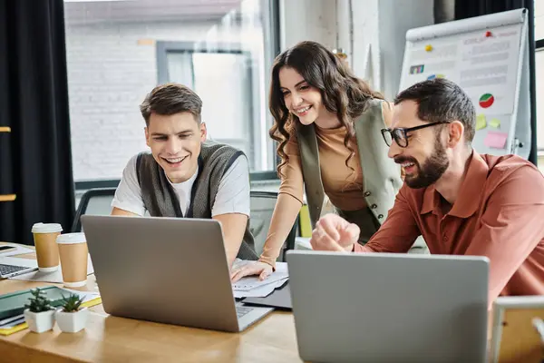 Three colleagues share a light moment at workplace. — Stock Photo