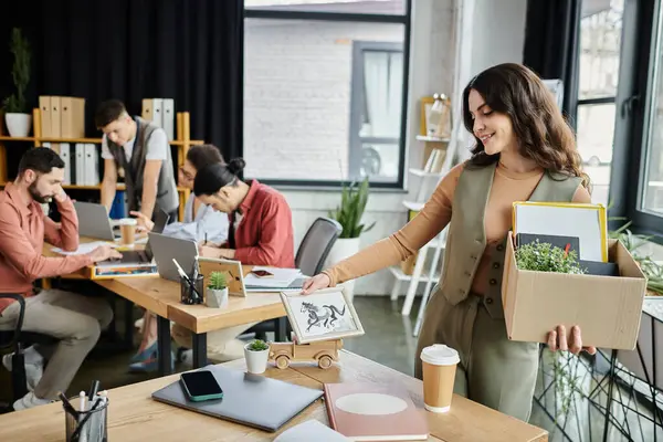 Жінка упаковує речі під час розкладання, колеги на фоні. — Stock Photo