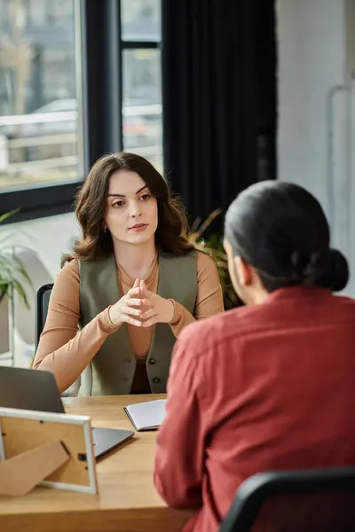 Professionals engage in a serious conversation about layoffs in a modern workspace. — Stock Photo