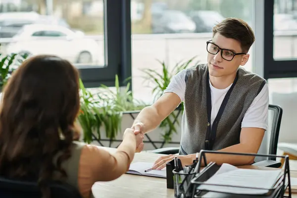 Two professionals engage in a supportive handshake amidst a tense moment. — Stock Photo