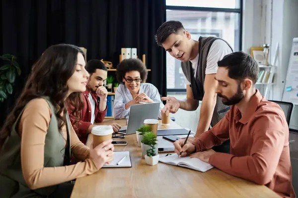 Team members engage in discussion while managing their work. — Stock Photo