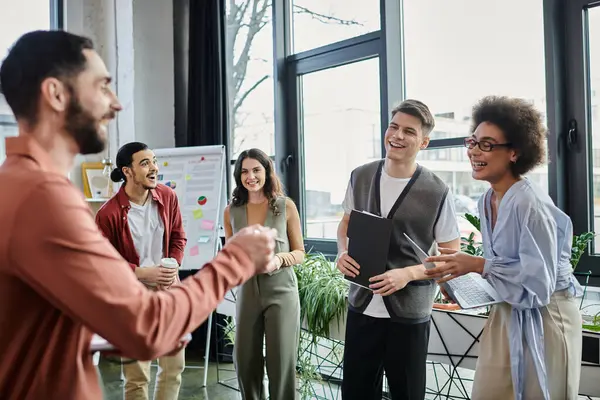 I colleghi condividono risate e conversazioni mentre affrontano un momento impegnativo. — Foto stock