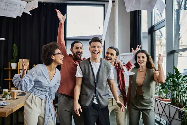 Colegas se reúnen alegremente en el lugar de trabajo. - foto de stock