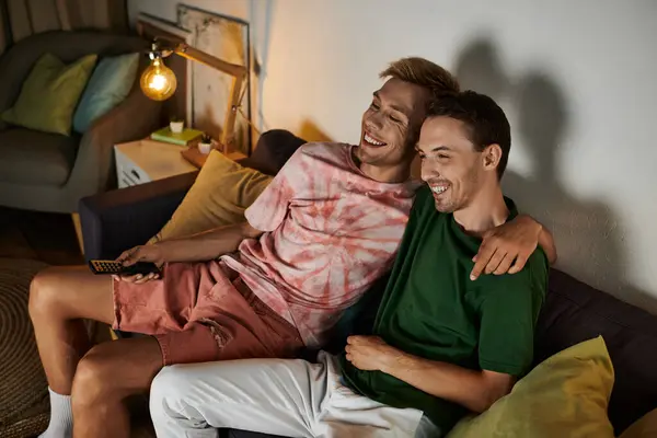 Two men share laughter and affection while lounging on the couch. — Stock Photo
