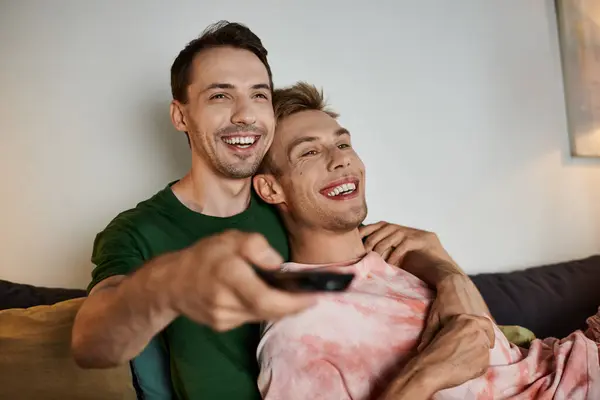 A couple relaxes on the couch, sharing laughter and love while watching TV. — Stock Photo