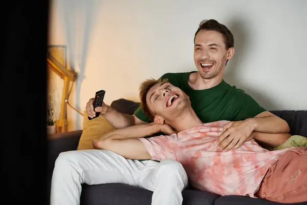 Two men share laughter and love on their cozy sofa at home. — Stock Photo