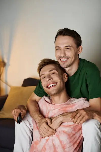 Two men share laughter and warmth while relaxing together at home. — Stock Photo