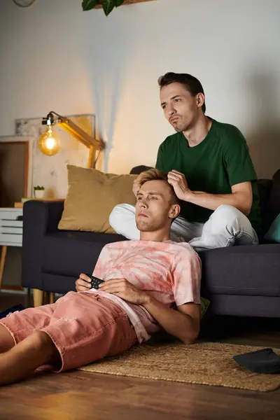 Two partners share a tender moment on the couch, surrounded by warmth and comfort. — Stock Photo
