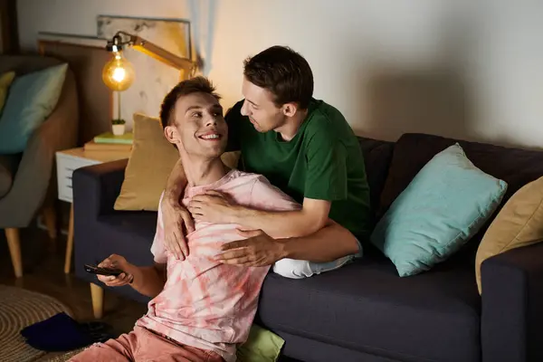 Two men share a joyful moment on the couch, cherishing their time together. — Stock Photo