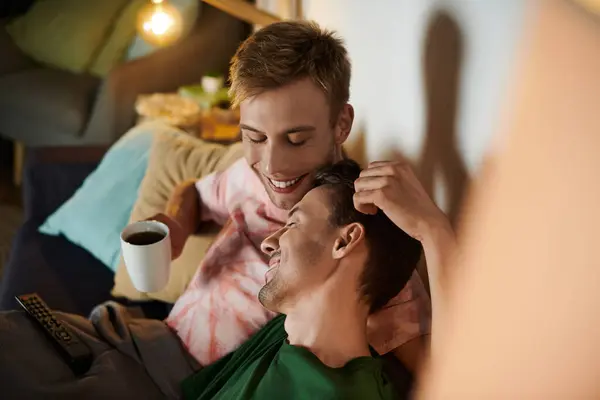 Two men share tender smiles while enjoying coffee and each other. — Stock Photo