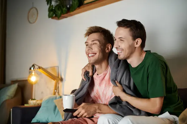 Two men share laughter and warmth while relaxing on the couch. — Stock Photo