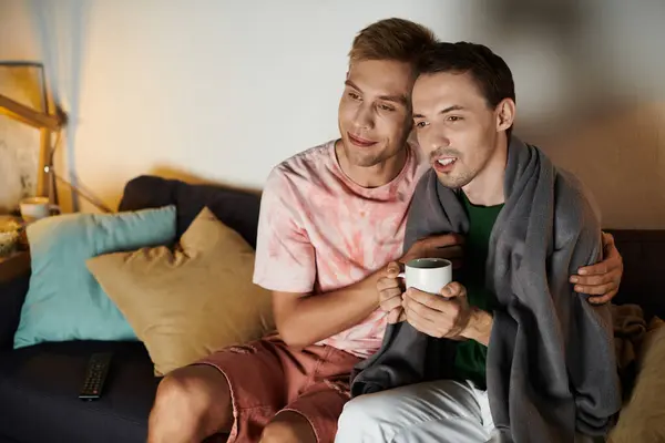 Two men share a sweet moment together on a cozy couch, enjoying each other. — Stock Photo