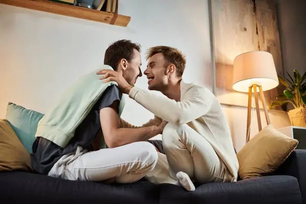 Dois homens desfrutam de um momento terno em seu espaço de vida convidativo. — Stock Photo