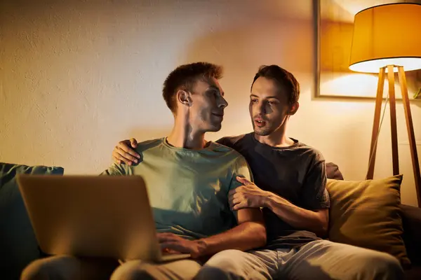 Two men share a tender moment while working on a laptop together. — Stock Photo