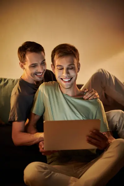 Two men share laughter and joy while watching something together. — Stock Photo