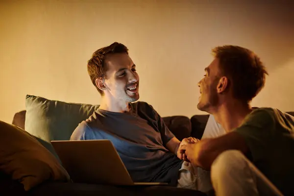 Two men share joyful moments while relaxing in their living room. — Stock Photo