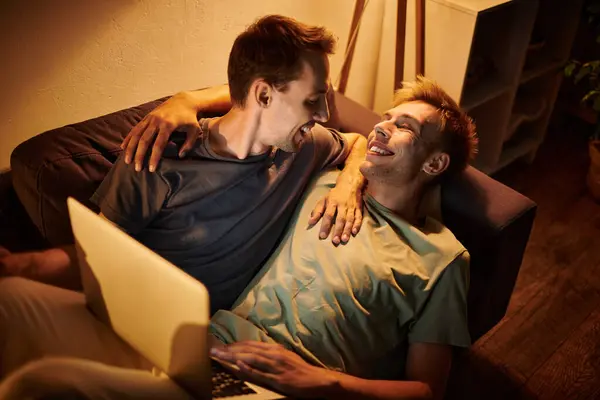 Two men share laughter and joy while relaxing on the couch. — Stock Photo