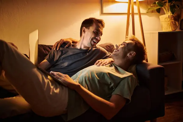 Two men enjoying each other on a cozy couch. — Stock Photo